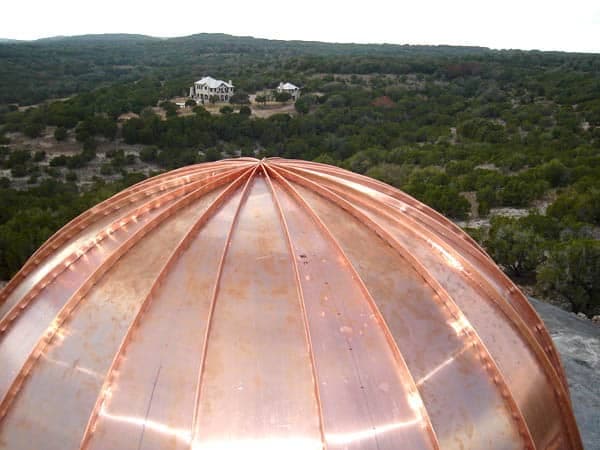 Aerial close-up of a fabricated copper dome roof, Texas hill country in the distance