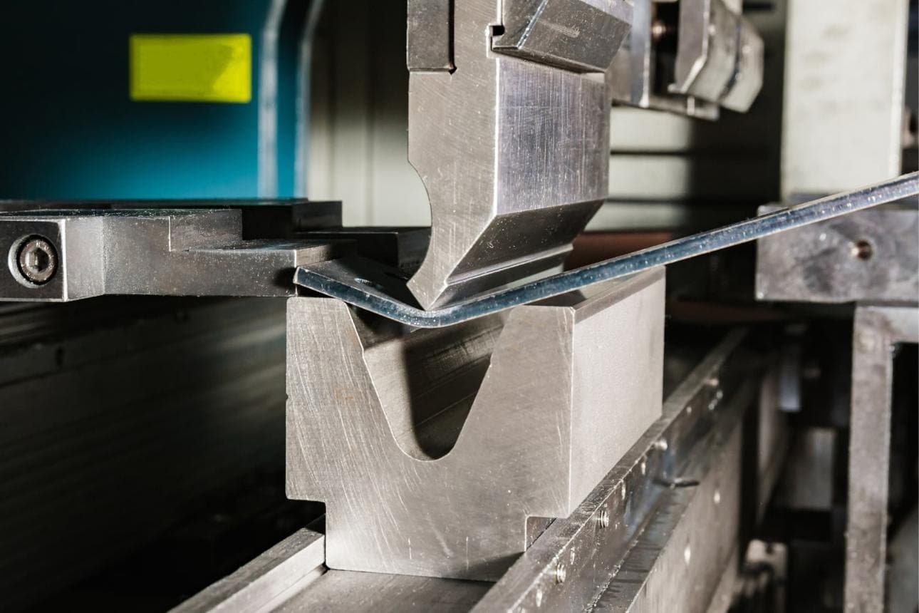 Close-up of a sheet-metal profile being bent on a folding machine